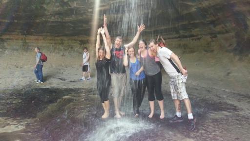 students standing under a waterfall